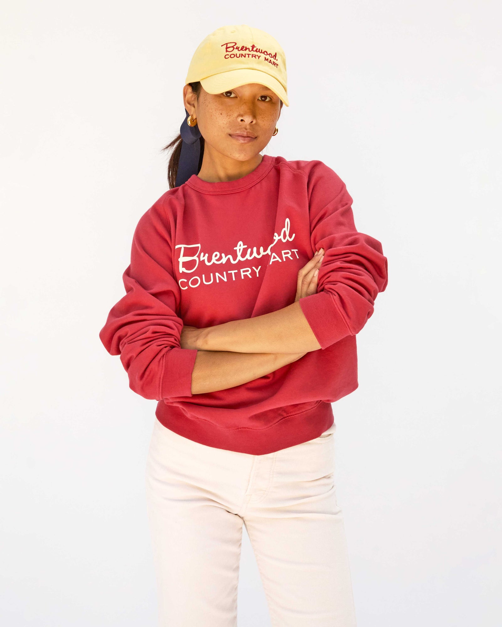 Maly wearing the Butter w/ Brentwood Red BCM Baseball Hat with the Brentwood sweatshirt with white pants