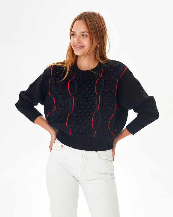 aurelia wearing the Black with red and navy chains Drop Shoulder Sweater with white jeans