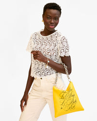 Dija wears the Foldover Clutch with Tabs with the Silver Shortie Strap