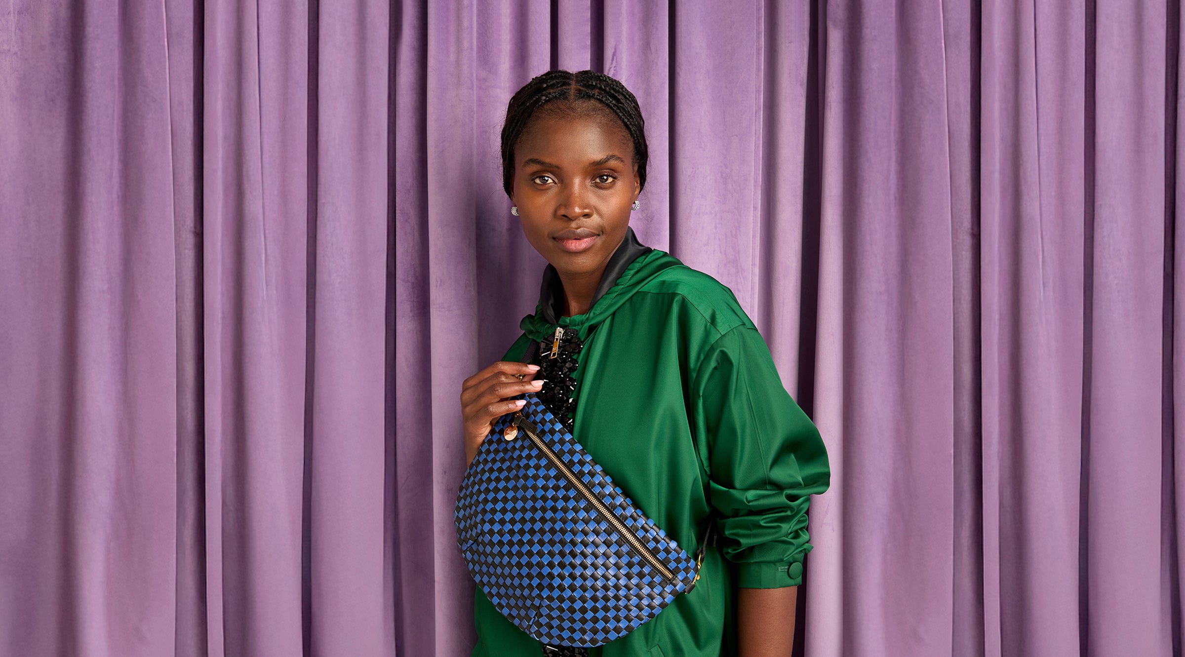 Model carrying the Black/Cobalt Woven Checker Grande Fanny over her chest.