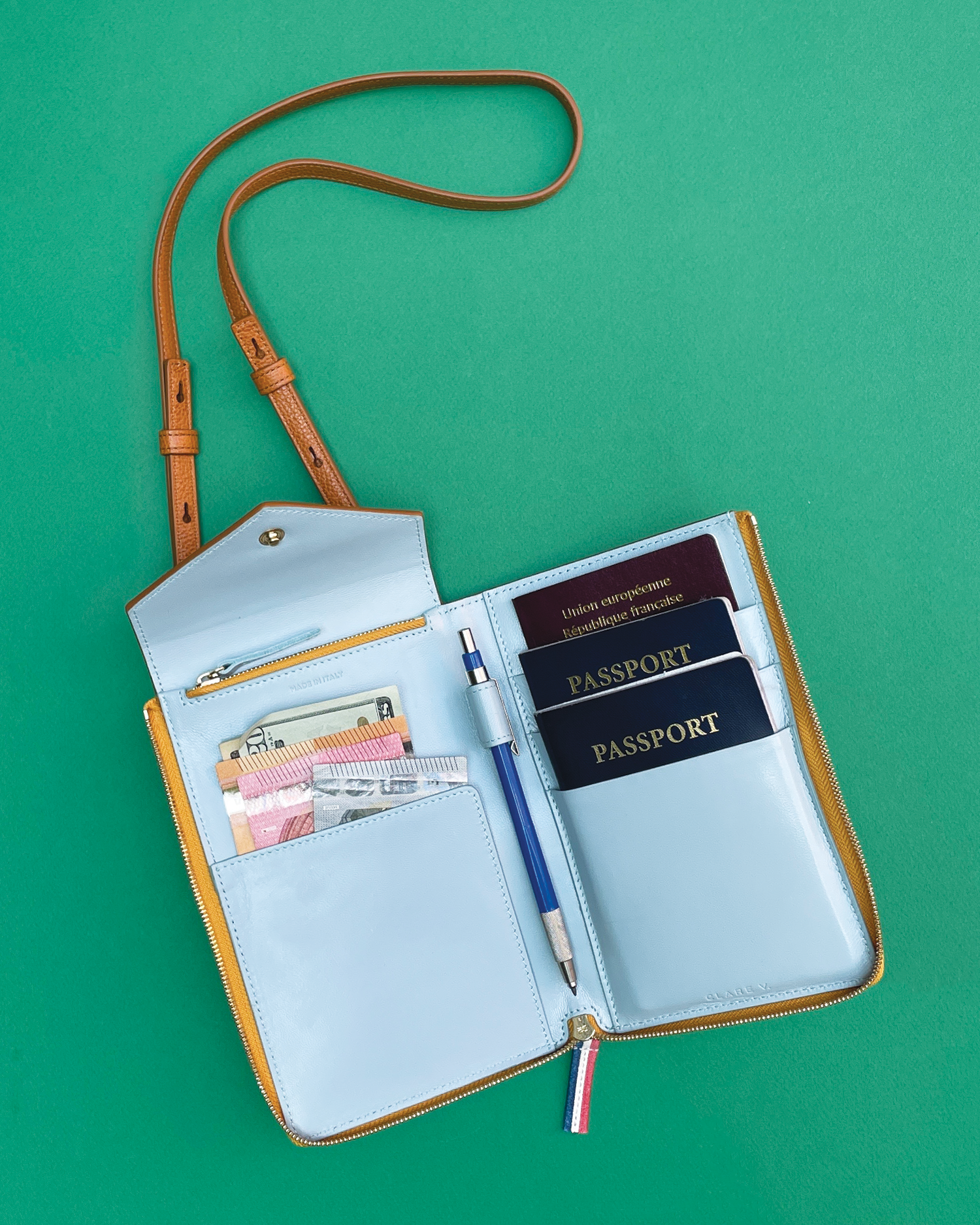 Jimmy Kimmel's Passport Case full of money and passports and a pen.