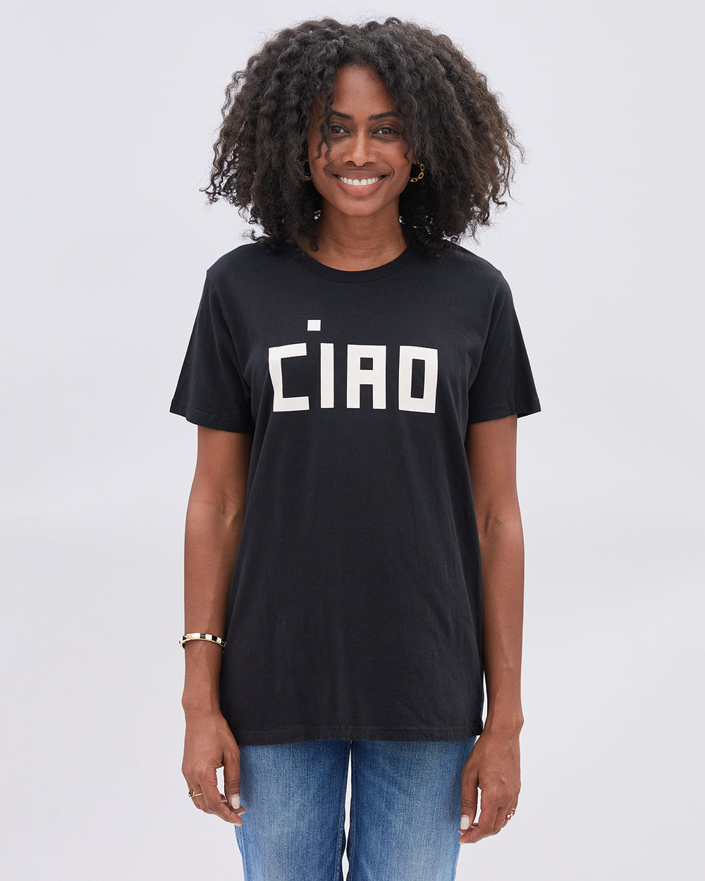 Mecca wearing the Ciao Original Tee in Black untucked with denim jeans.
