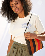Mecca wearing the Cream Bourgouise Sauvage Original Tee tucked in to an olive colored skirt