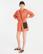 danica wearing the Poppy & Khaki Checker St. Martin Top with the Poppy & Khaki Checker St. Martin shorts and the black rattan poche