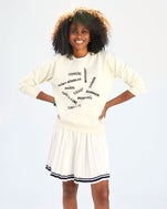 Mecca wearing the Sweatshirt in Cream with Valle de Loire with a white tennis skirt