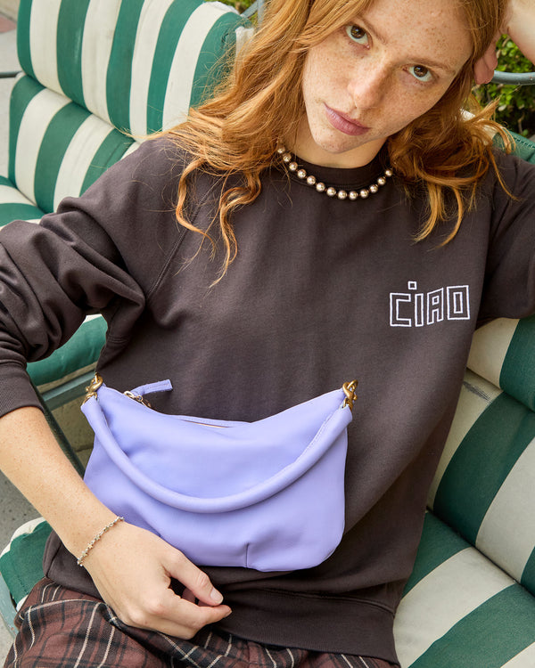 Haley wearing the Cocoa Oui Sweatshirt with plaid pants. she has the violet petit moyen on her lap