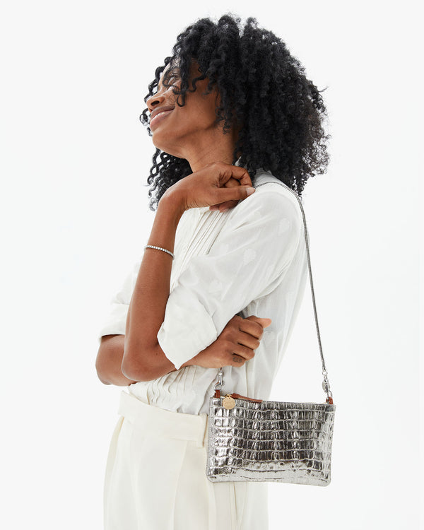 Mecca with the Silver Metallic Croco Wallet Clutch w/ Tabs on her shoulder with the silver snake chain shoulder strap