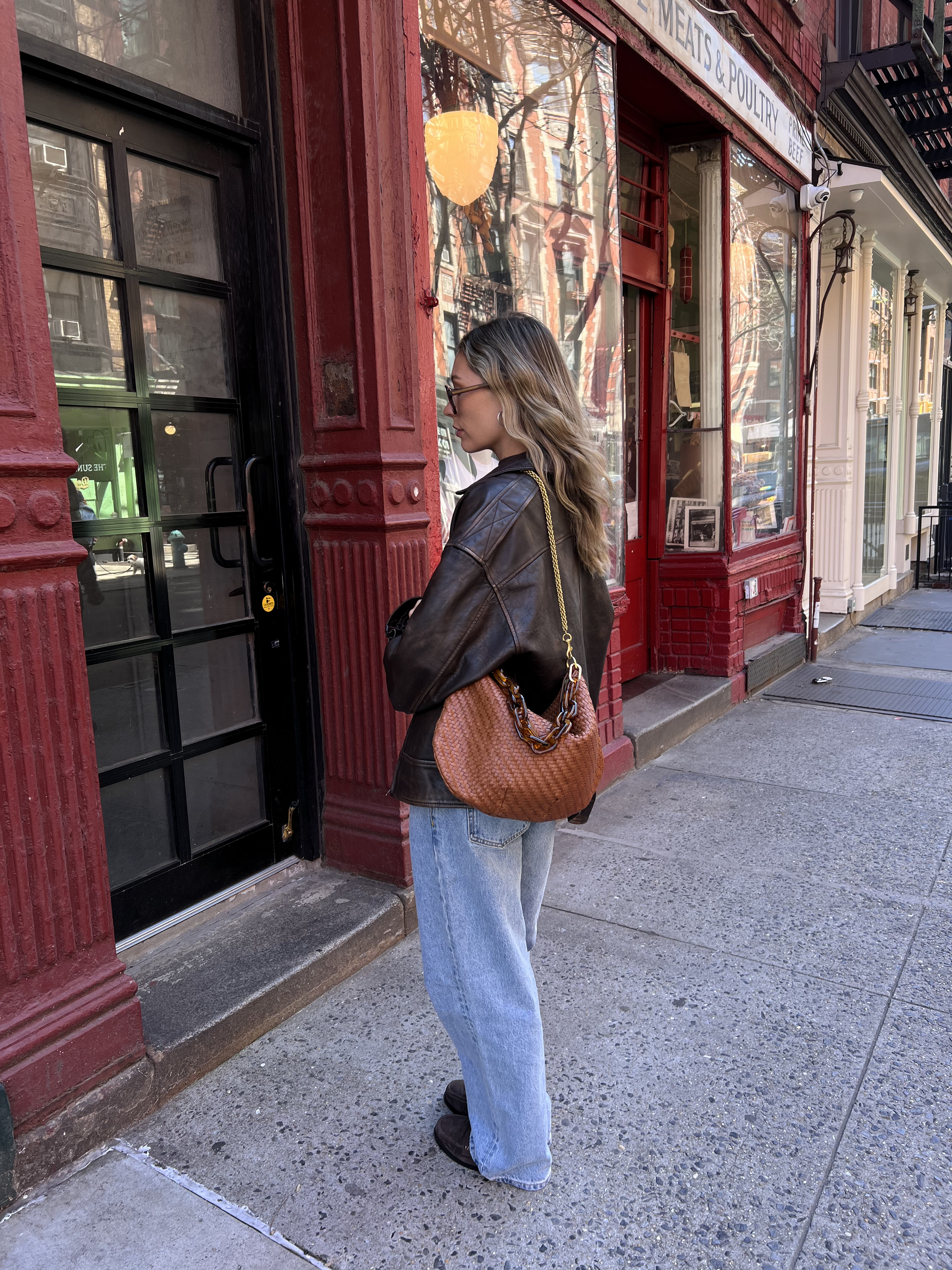 Model carrying the Natural Woven Checker Moyen Messenger with additional bag straps.