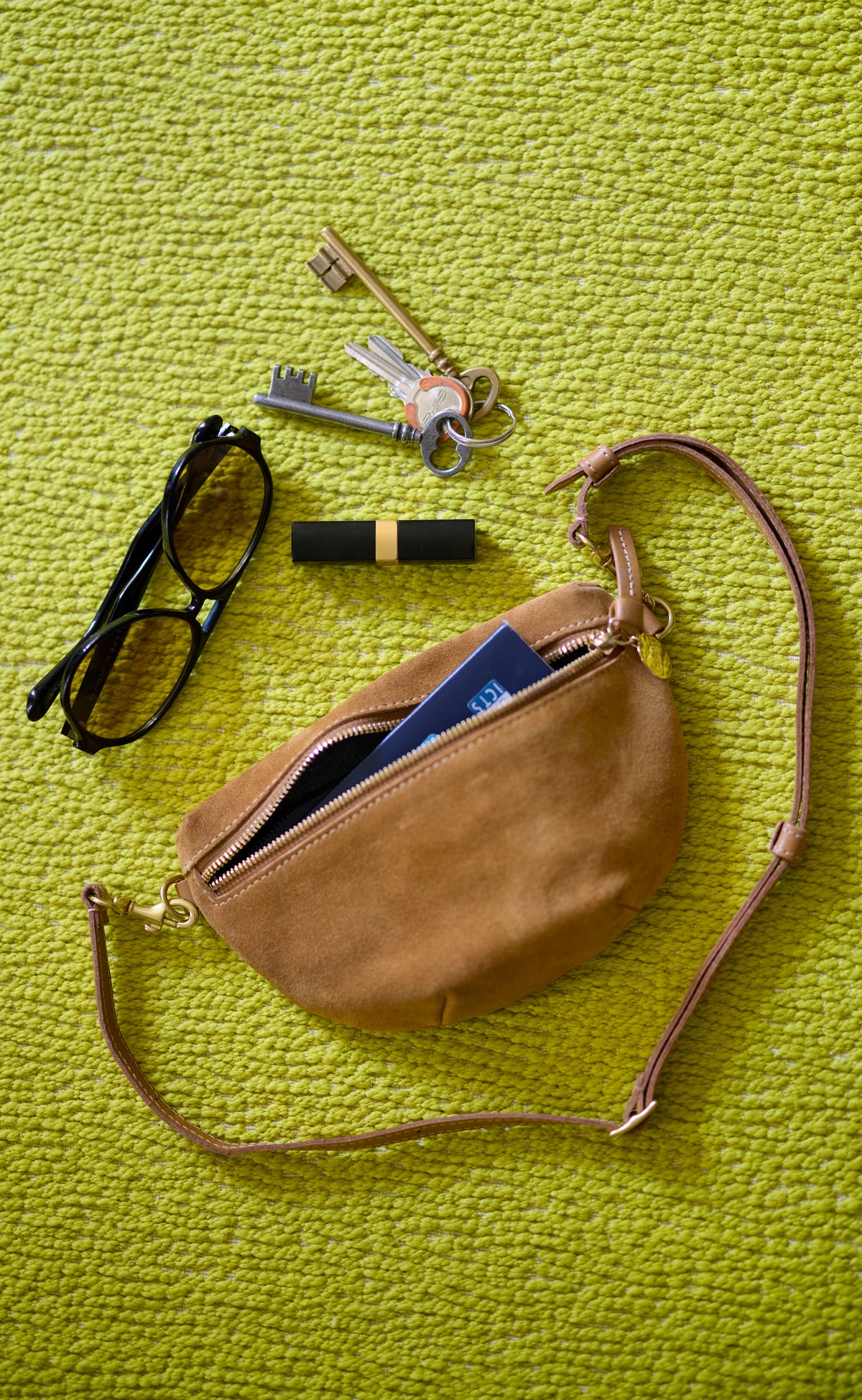 Caramel Suede Petit Fanny unzipped with items sticking out. 