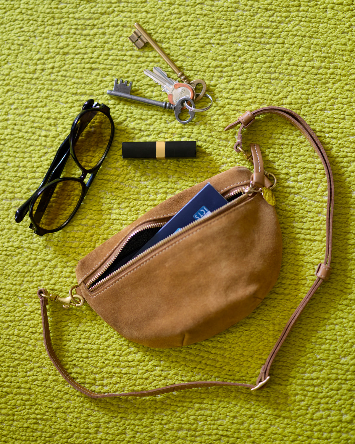 Caramel Suede Petit Fanny unzipped with items sticking out. 