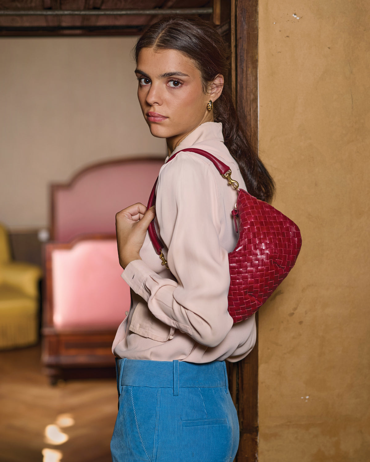 Model carrying the Garnet Diagonal Woven Petit Moyen as a shoulder bag. 