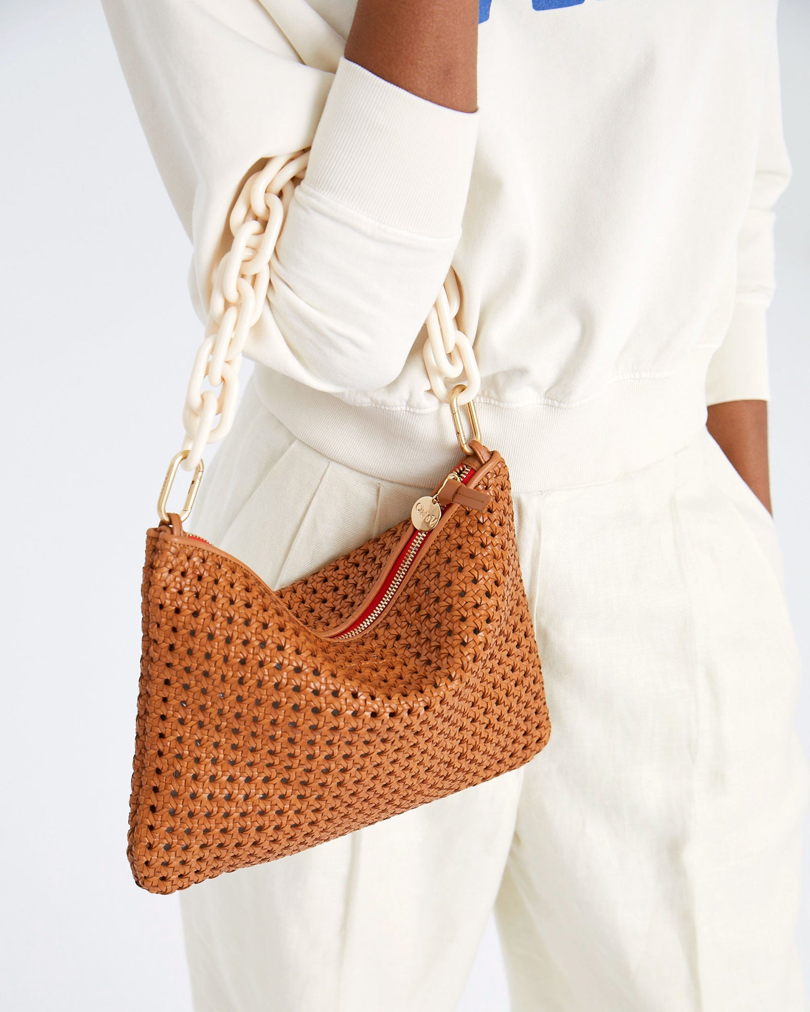 mecca carrying the Tan Rattan Flat Clutch w/ Tabs by the cream resin shortie strap