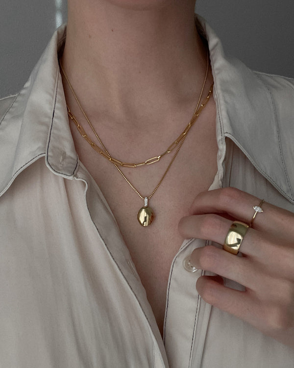 model wearing the Maison Oval Locket Necklace II with another necklace