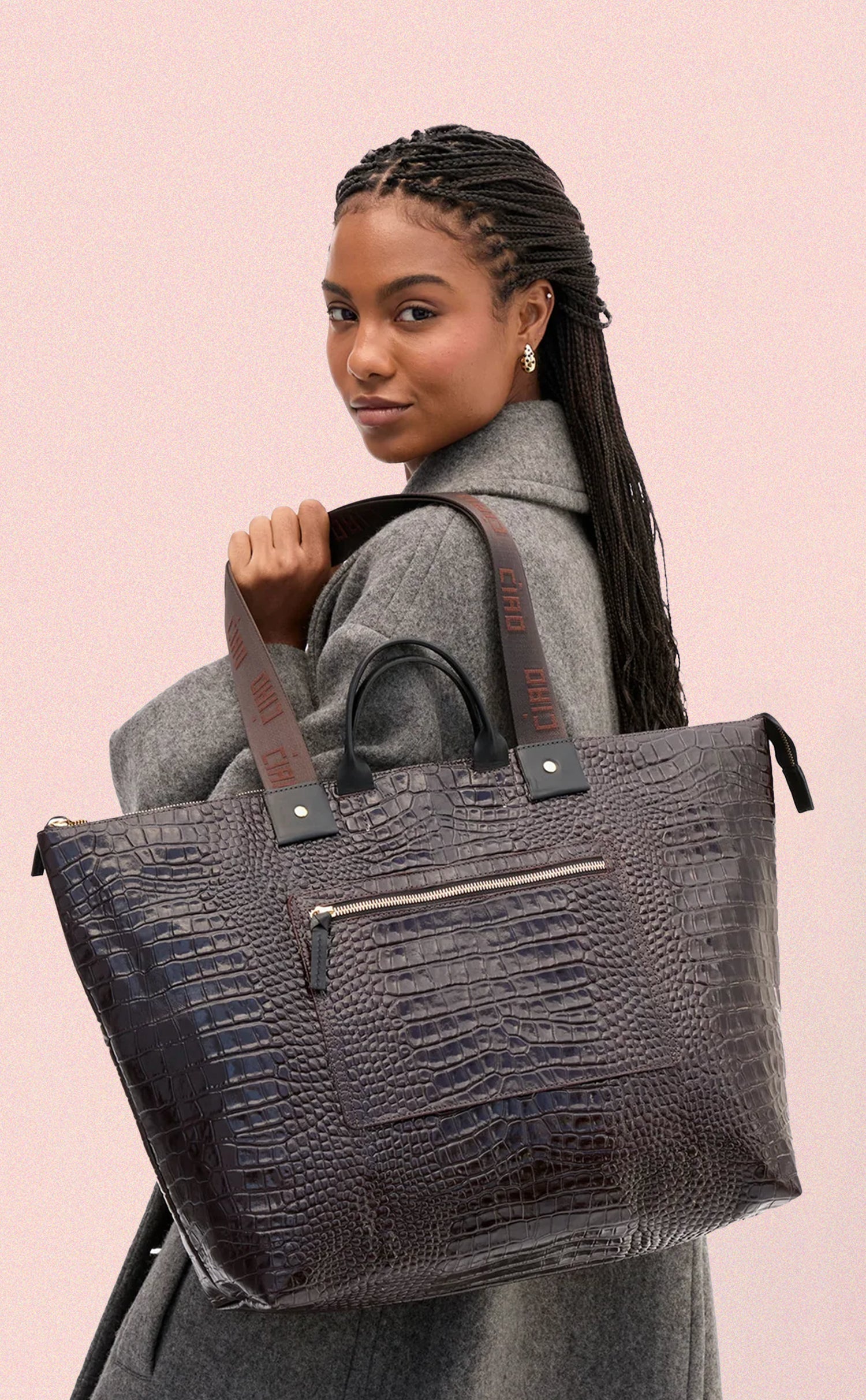 Model carrying the Mahogany Embossed Croco w/ Travel Pocket Grand Zip Sac.  