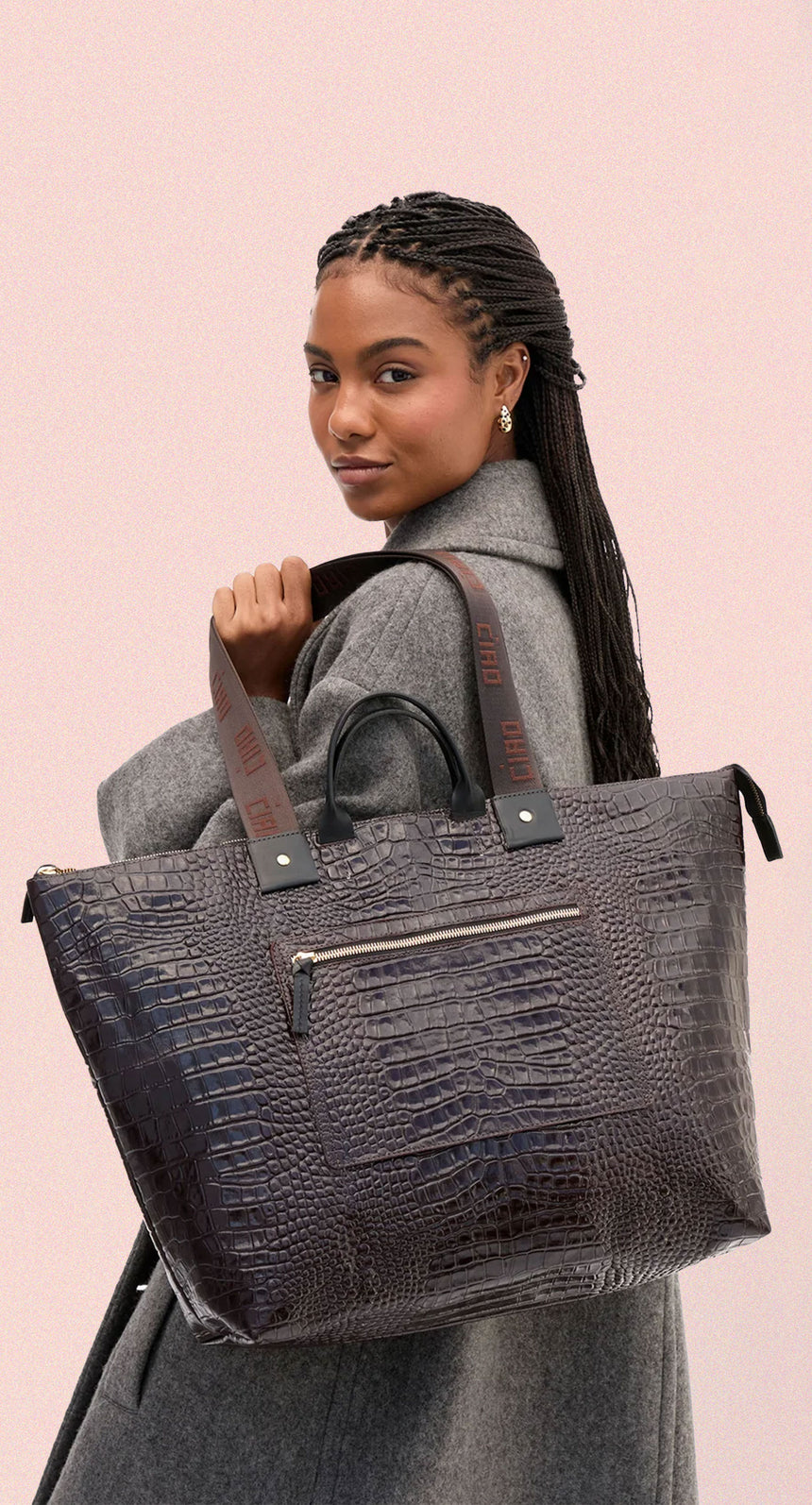 Model carrying the Mahogany Embossed Croco w/ Travel Pocket Grand Zip Sac.  