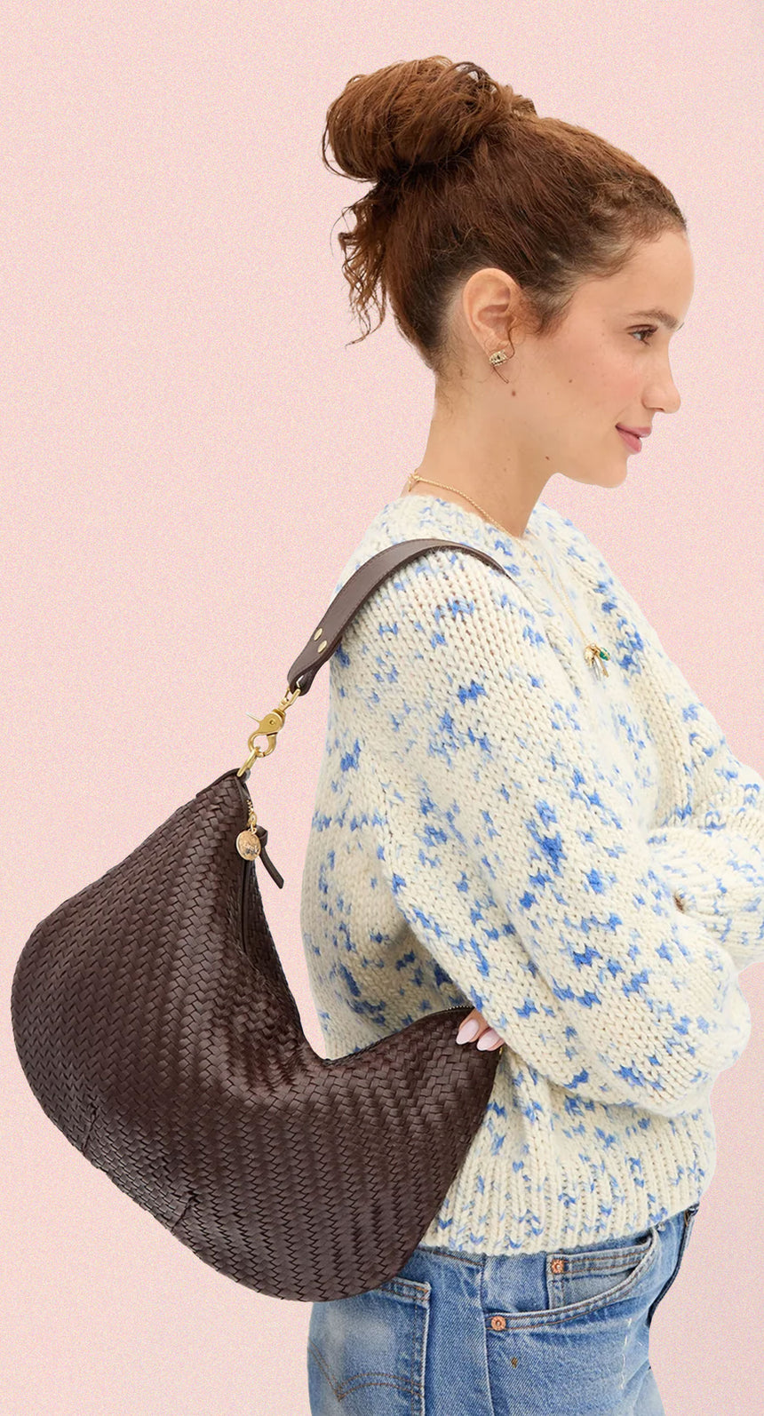 Model carrying the Chocolate Woven Zig-Zag Moyen Messenger as a shoulder bag. 