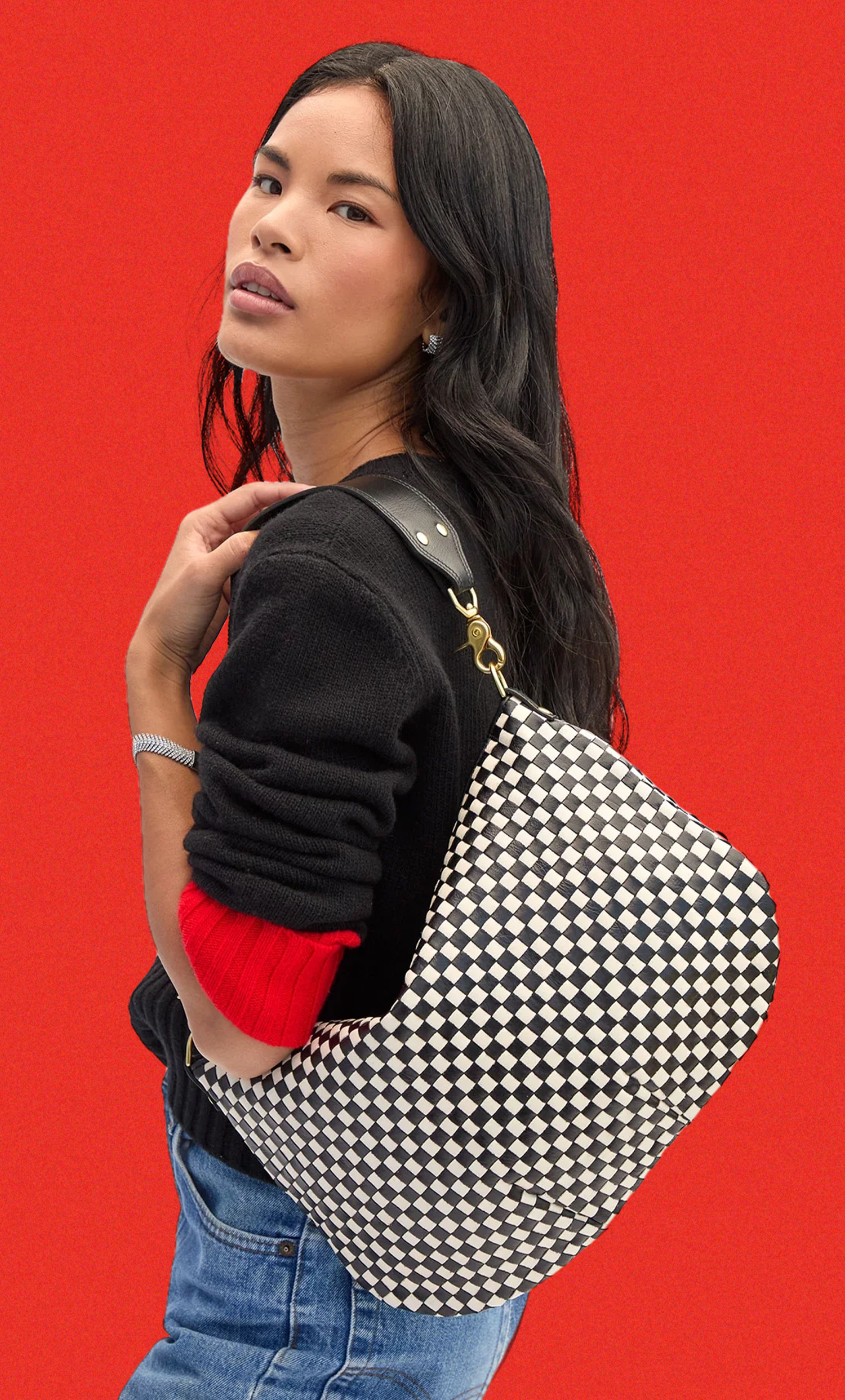 Model carrying the Black and Cream Checker Moyen Messenger over her shoulder. 