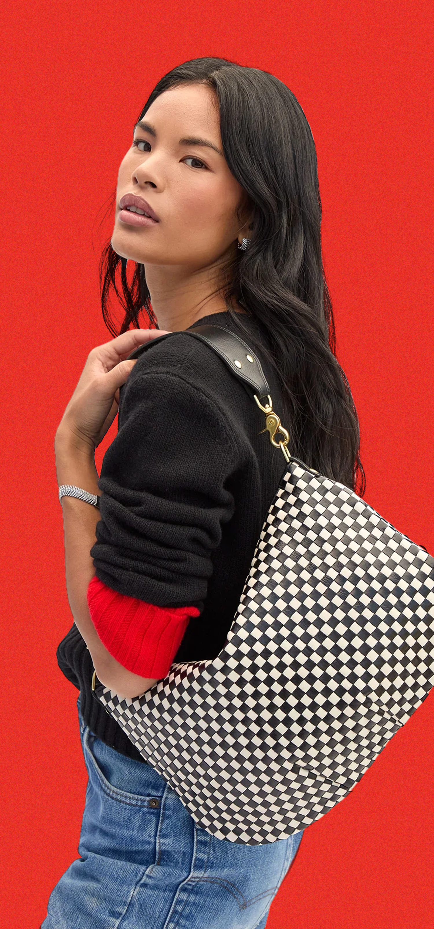 Model carrying the Black and Cream Checker Moyen Messenger over her shoulder. 