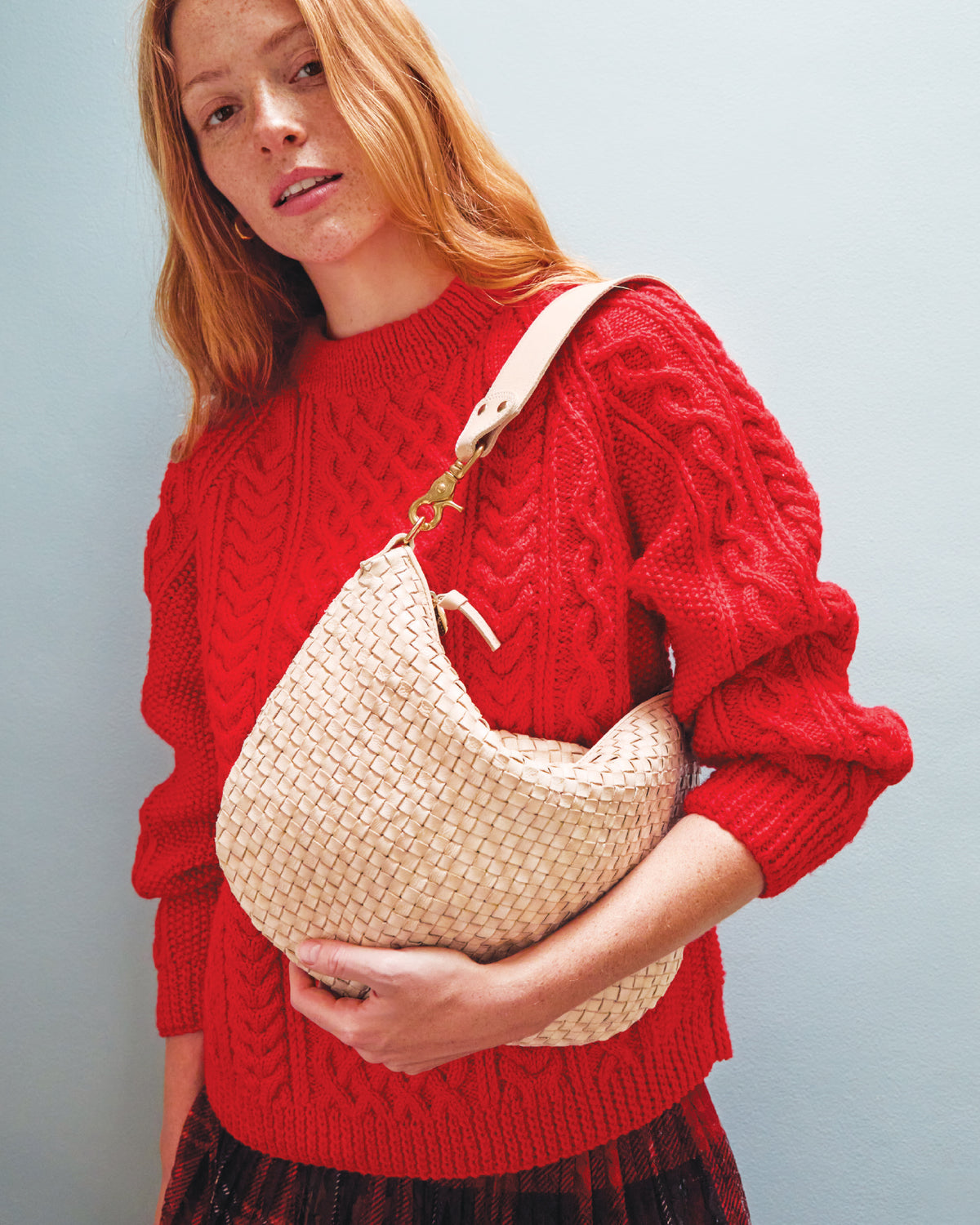 Woman carrying the Cream Woven Checker Moyen Messenger as a shoulder bag. 