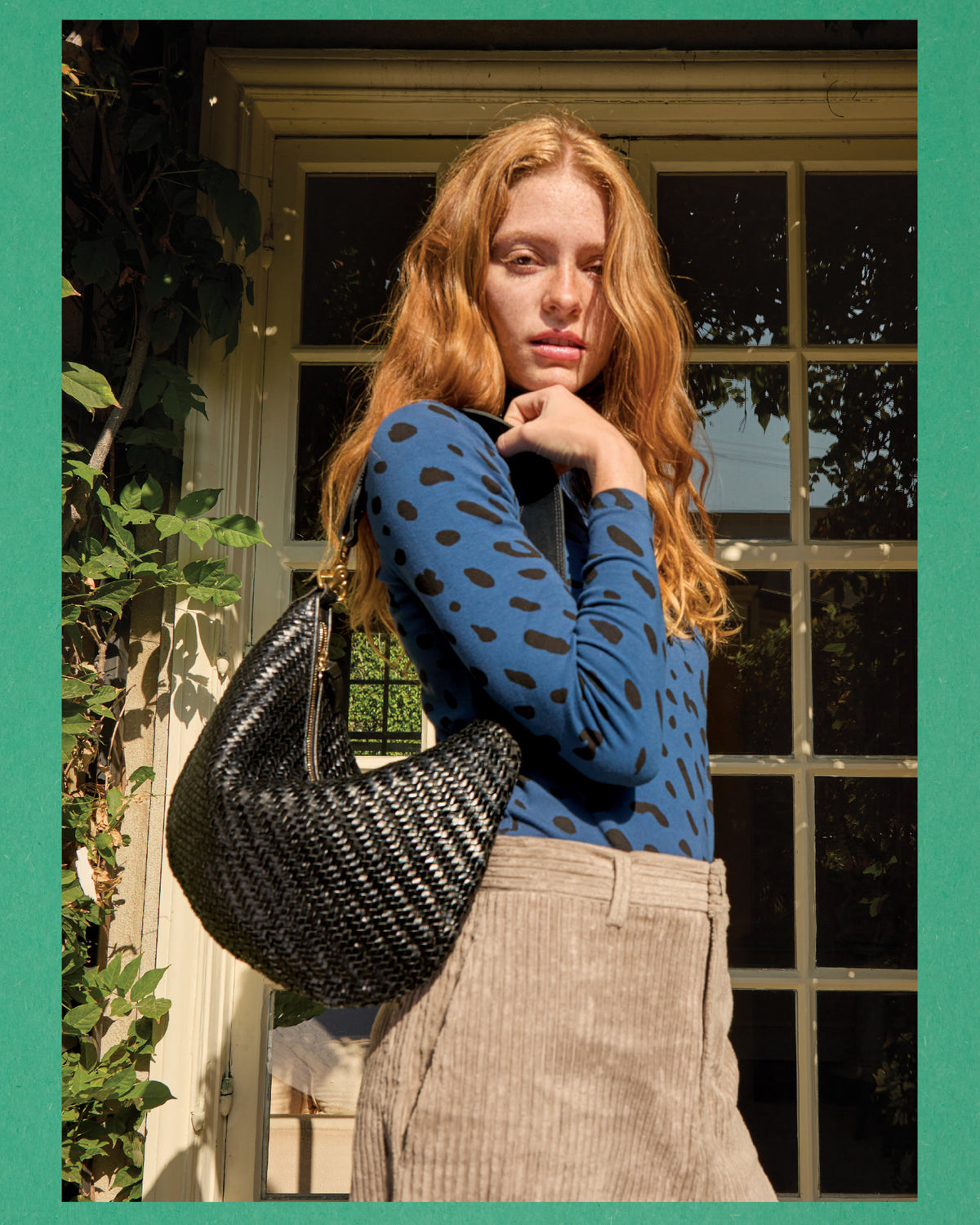 Model wearing Le Turtleneck in Faded Marine Jaguar and carrying the Black Woven Zig-Zag Moyen Messenger.
