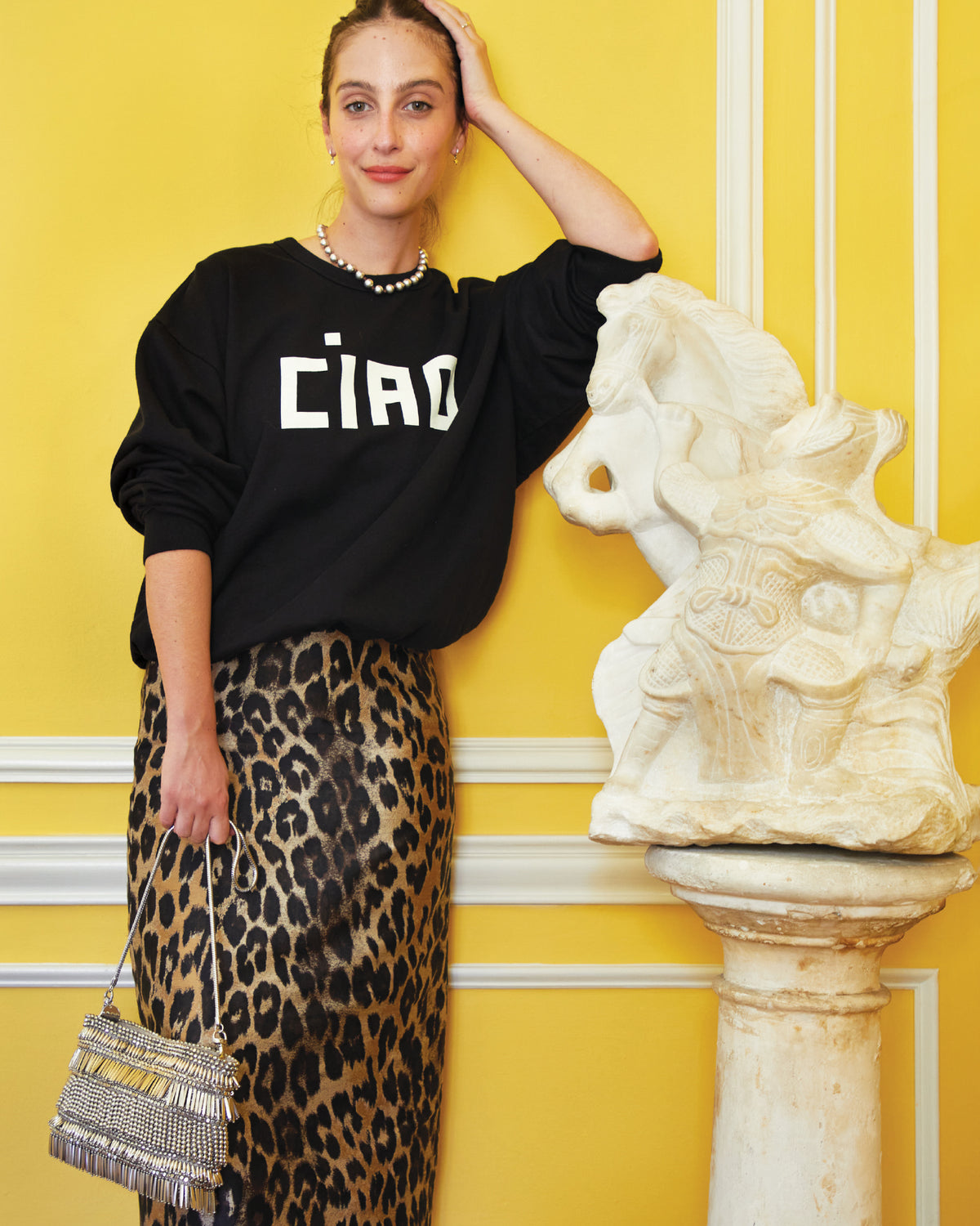 Frannie wearing the Black Oversized Sweatshirt with a leopard pencil skirt and carrying the Silver Beaded Fringe Estelle. 