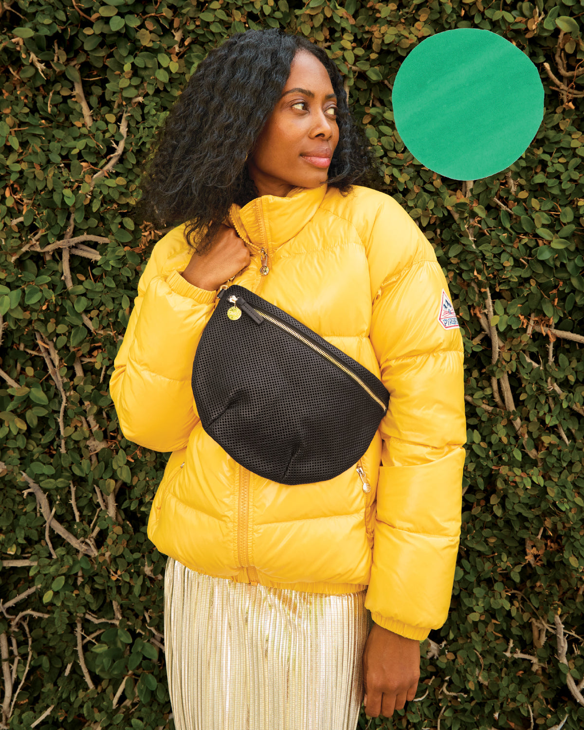 Mecca wearing the Pyrenex Vintage Mythic Puffer Coat with the Black Perf Grande Fanny worn over it, across her chest. 