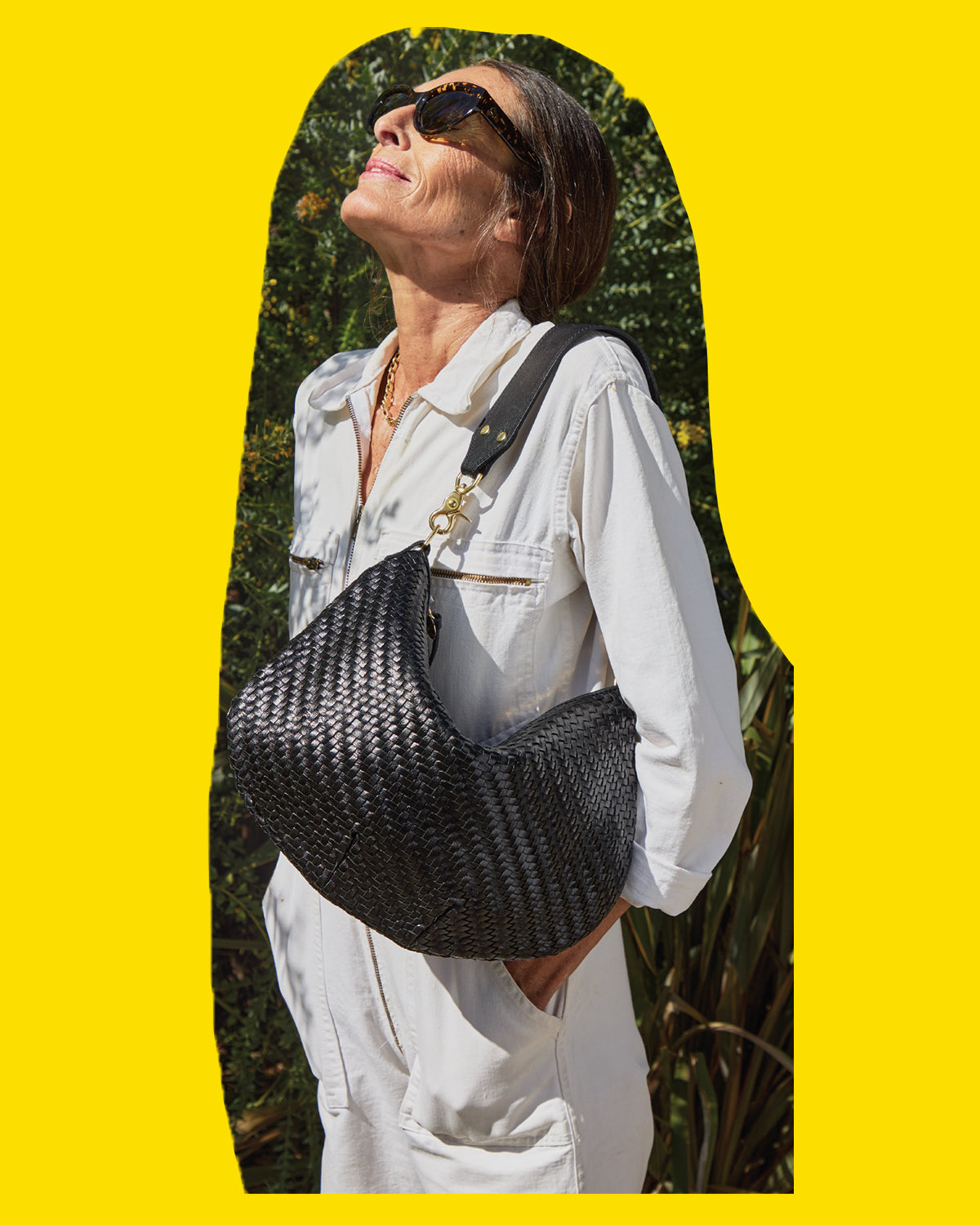 Model wearing the Sophia Tortoise Sunglasses and carrying the Black Woven Zig Zag Moyen Messenger.