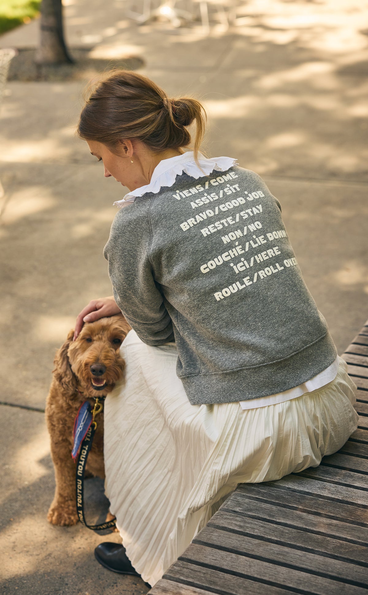 Model wearing the Grey Le Court Sweatshirt with a ruffle collar and long silk pleated skirt. 
