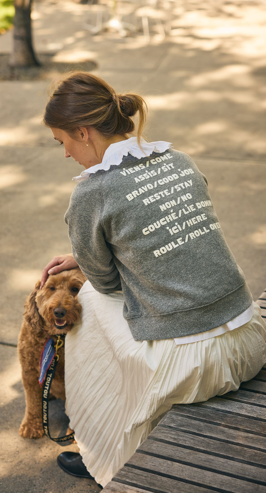 Model wearing the Grey Le Court Sweatshirt with a ruffle collar and long silk pleated skirt. 