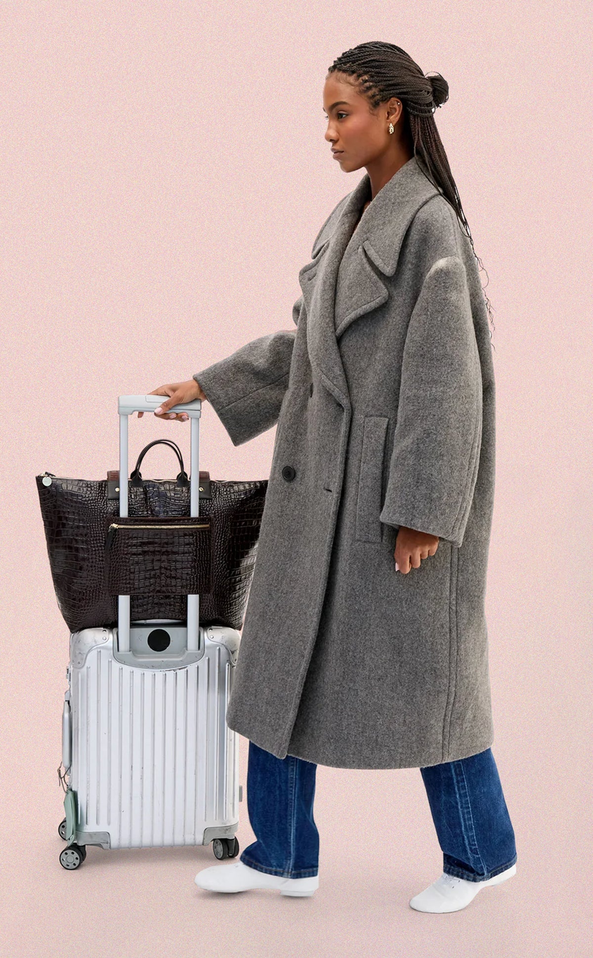 Model with the Grand Zip Sac sitting over her luggage and attached to it via the exterior zip pocket. 