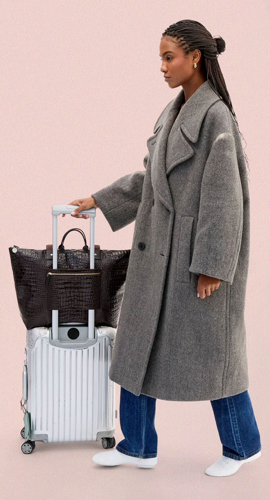 Model with the Grand Zip Sac sitting over her luggage and attached to it via the exterior zip pocket. 