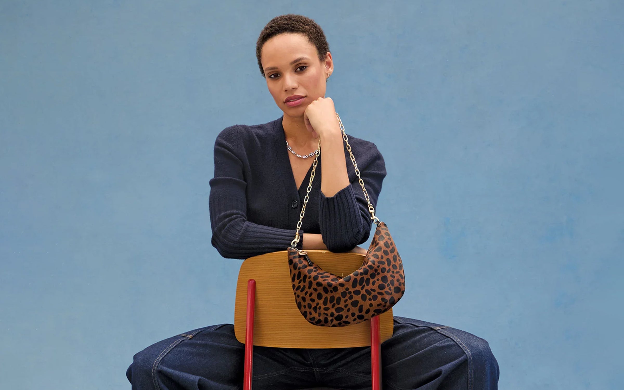 Model carrying the Leopard Lune with a Gold Oval Chain Shoulder Strap.