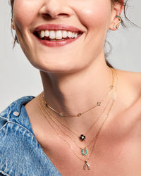 Model wearing the Adina Reyter Baguette Wishbone Necklace along with other adina reyter jewelry