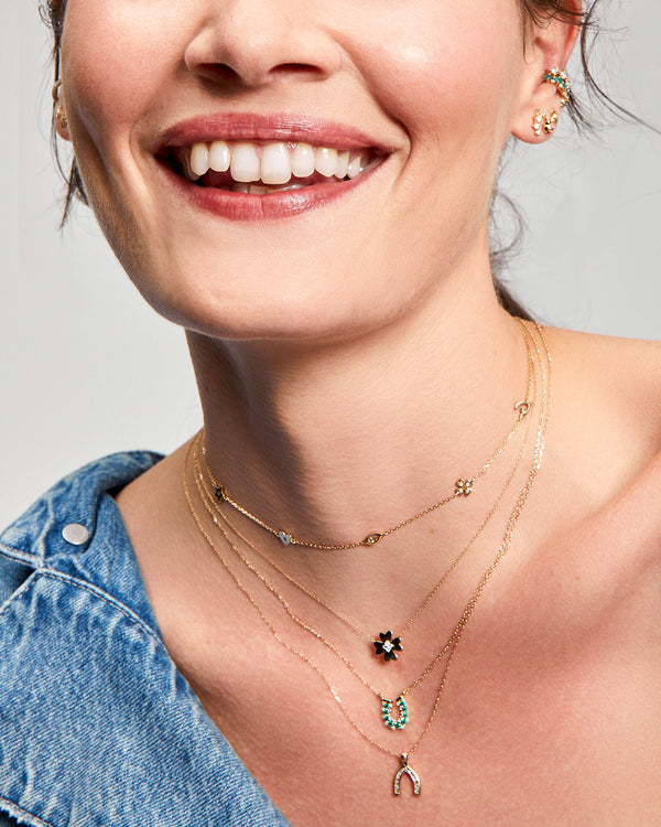 Model wearing the Adina Reyter Baguette Wishbone Necklace along with other adina reyter jewelry