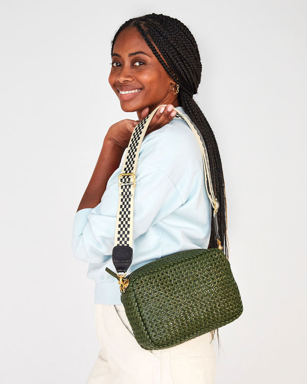 mecca holding the army rattan marisol by her shoulder by the black and cream adjustable webbing strap