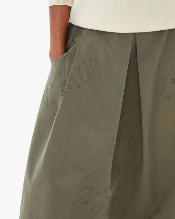 close up of the embroidery on the Olive Quilted Anais Midi Skirt. mecca's hands are in the skirt's pockets