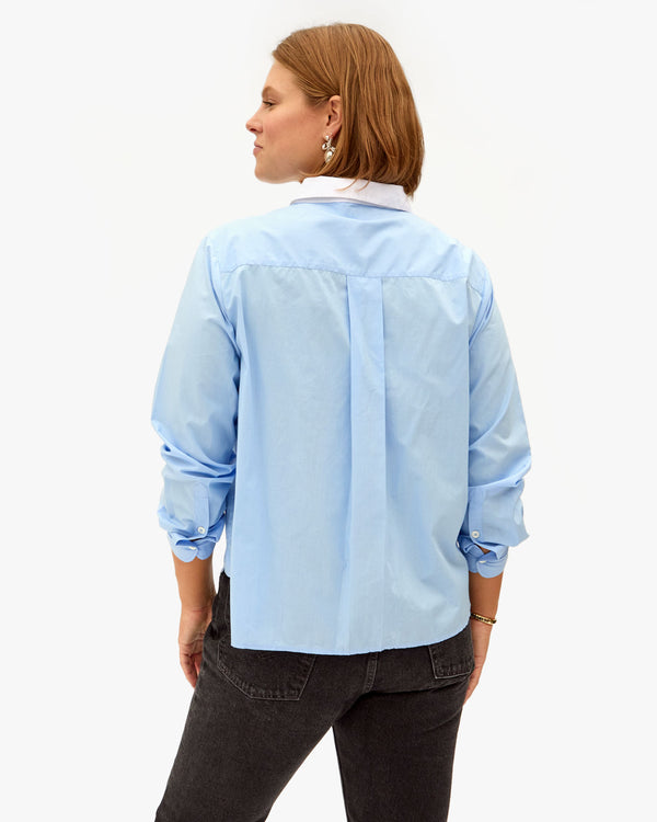 Back View of Sonnie wearing the French Blue Anette Tuxedo Shirt with black jeans