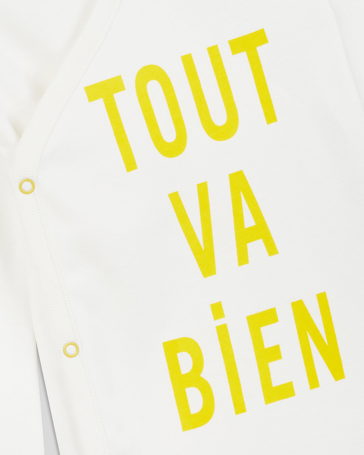 close up of the print and the side snaps on the Cream w/ Marigold Tout va Bien Baby Onesie