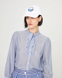 athena wearing the white with black and cobalt maison bourgneuf Baseball Hat  with her hair tucked behind her ear