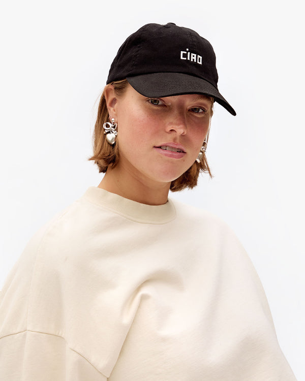 Sonnie wearing the Black Ciao Baseball Hat with the cream le drop fringe
