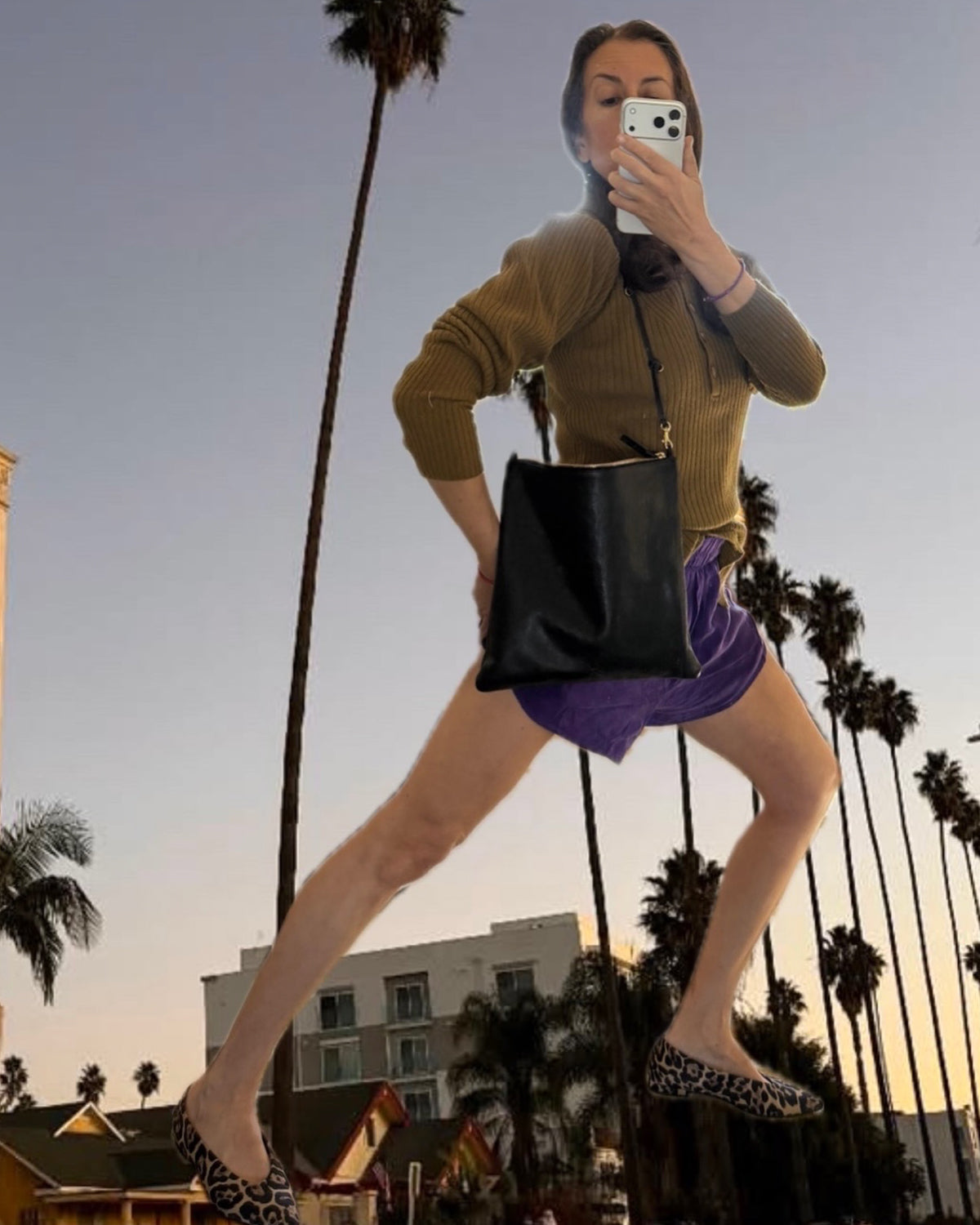 Clare taking a selfie picture to show her Black Petit Caviar Foldover Clutch with Tabs paired with a Shoulder Strap. 