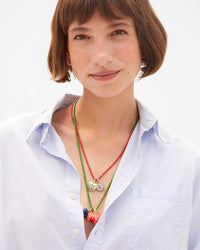 Kathie wears an assortment of charms on the enamel barrel bead necklaces