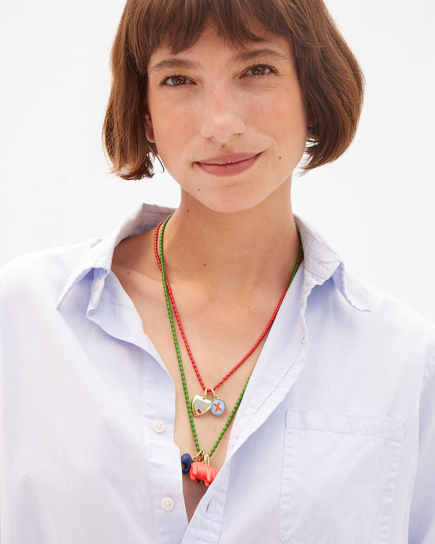Kathie wears an assortment of charms on the enamel barrel bead necklaces