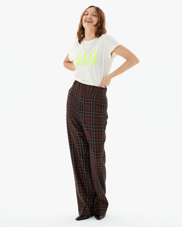 Zoe wearing the Cream Oui Classic Tee tucked in to plaid pants with her hands on her hips