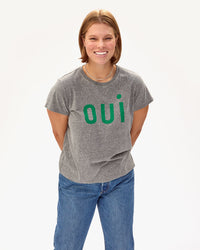 Sonnie wearing the Classic Tee in Grey Oui with jeans. she has her hands clasped behind her back 