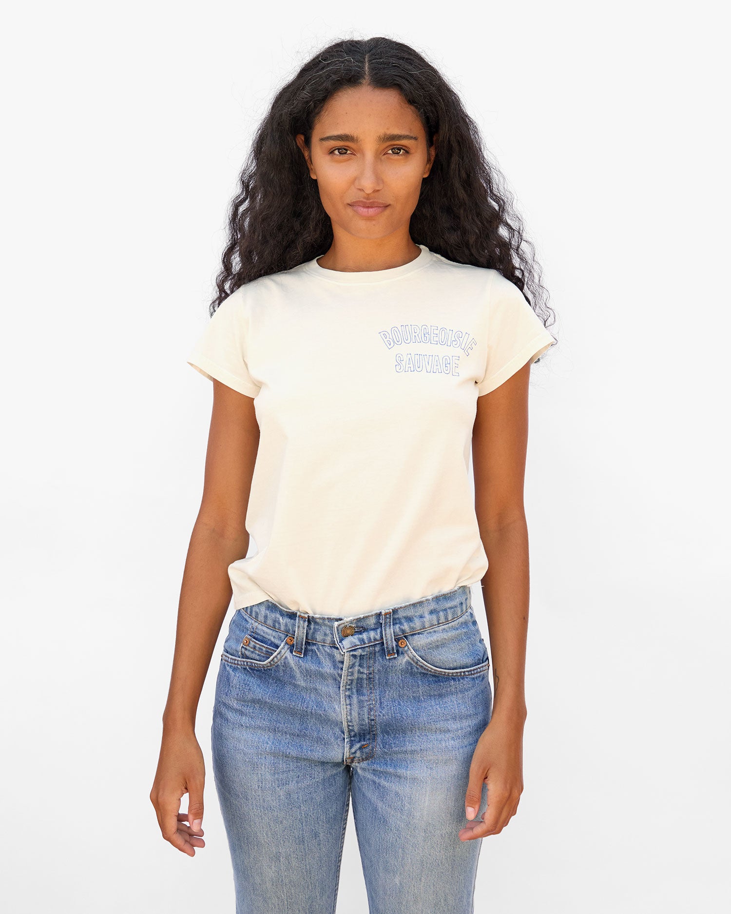 Jade standing with her arms at her sides wearing the Cream Bourgeoisie Sauvage Classic Tee and jeans