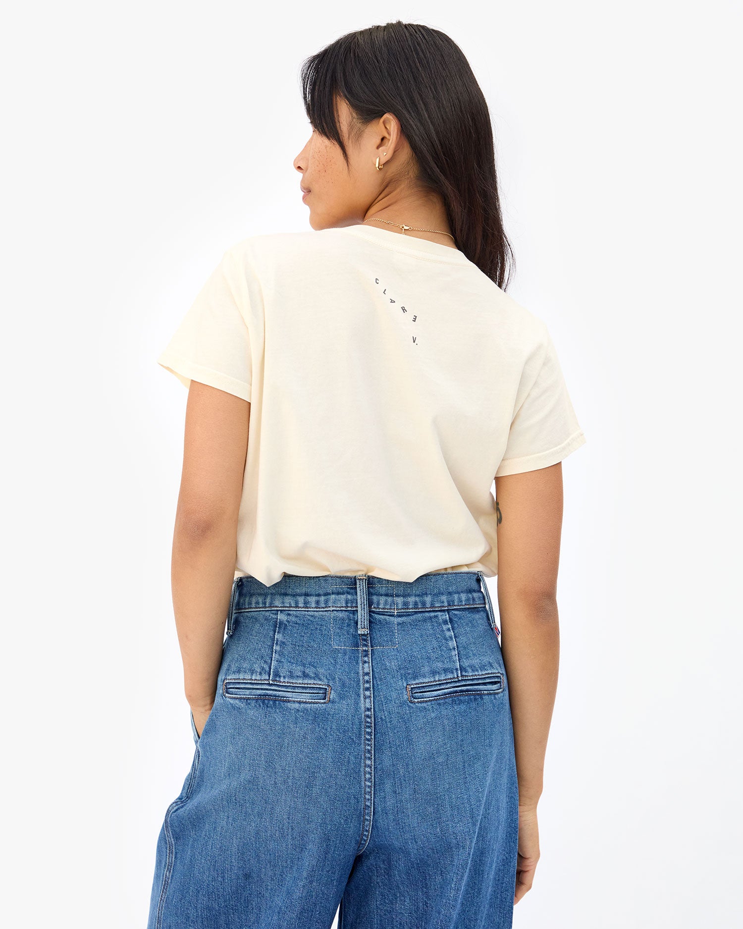 back view of Maly in the Cream Oui Classic Tee with jeans