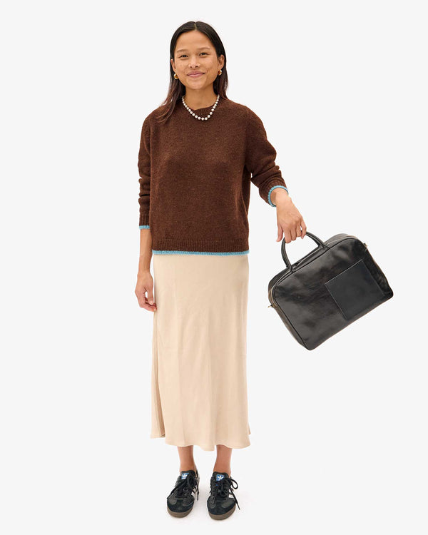 Maly in a brown sweater and tan skirt with the Black Claude