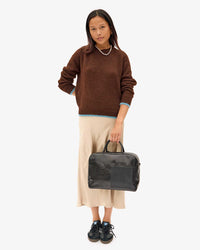 Maly standing facing the camera holding the Black Claude in her left hand
