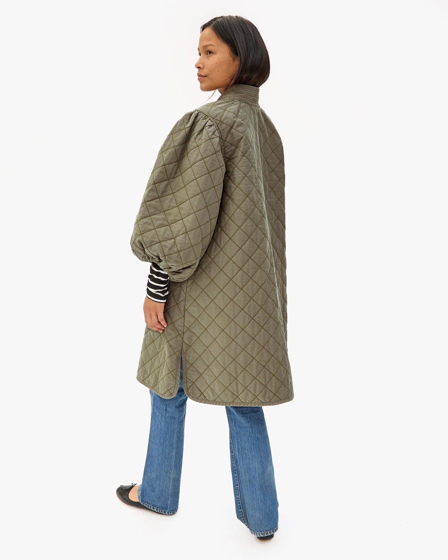 Profile view of Maly wearing the Olive Quilted Clemence Car Coat.